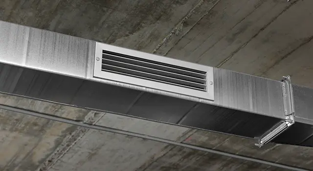 HVAC galvanized duct and vent mounted on a concrete ceiling.